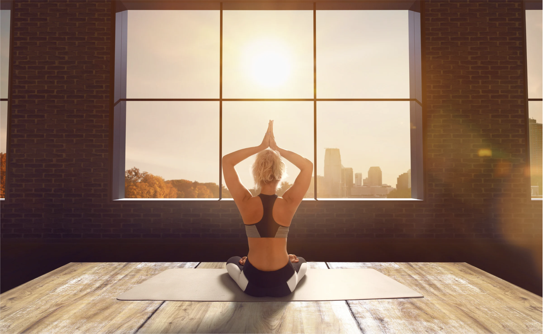 Woman practicing yoga at sunrise — Dinacharya, the Ayurvedic daily routine, anchors the nervous system through consistent rhythm